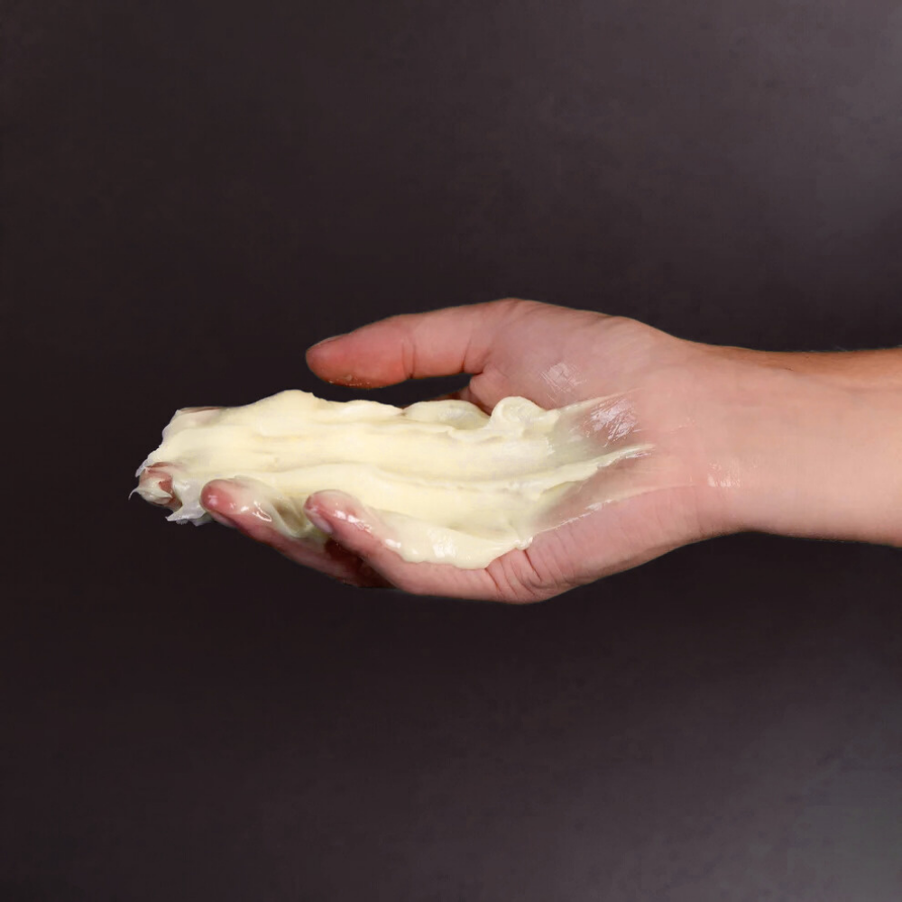 A hand holding a creamy skin repair product, related to DERMA PRO skin repair and protection.