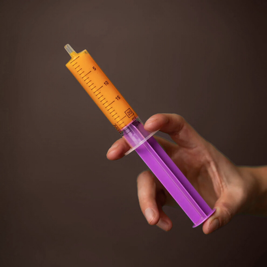 TRM FOAL CARE nutritional supplement dosing syringe for foals in a hand, designed for easy administration.