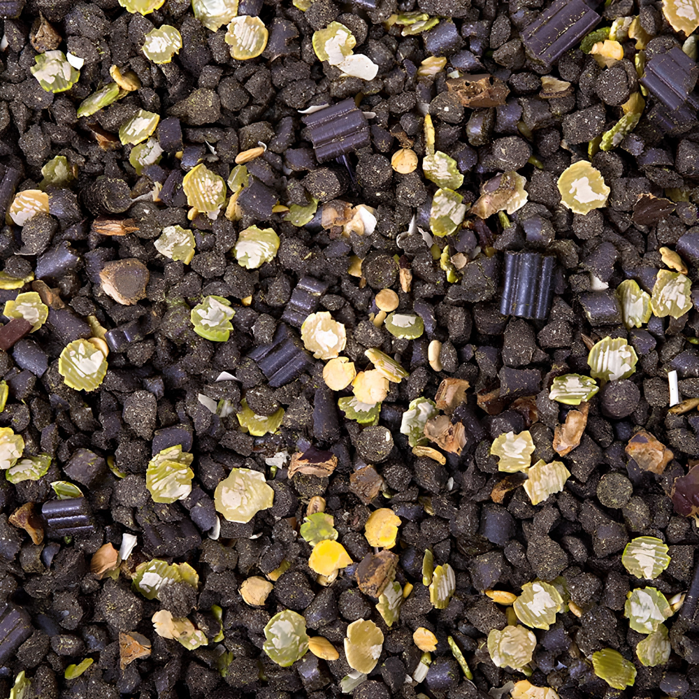 Close-up of PUR.SPORT horse feed blend featuring black, green, and yellow granules for enhanced nutrition.
