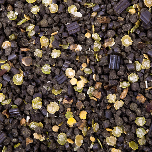 Close-up of PUR.SPORT horse feed blend featuring black, green, and yellow granules for enhanced nutrition.