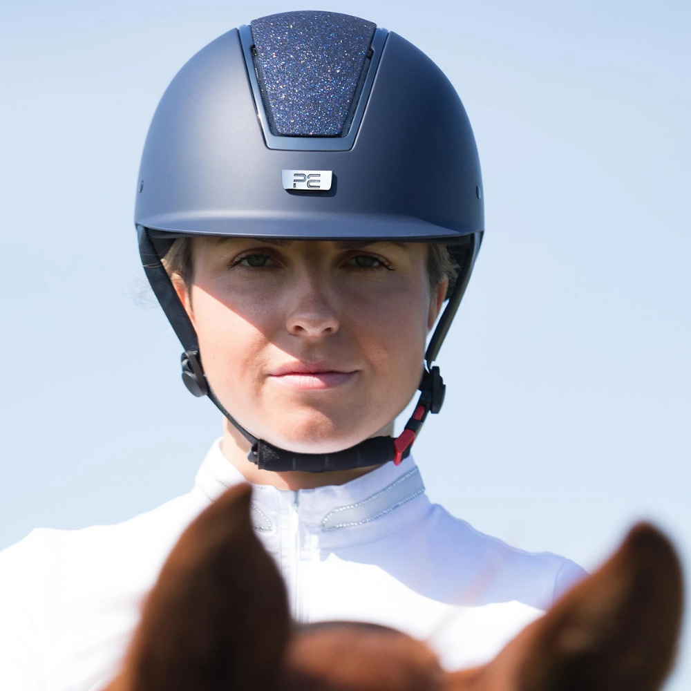 Alzarrab PE Odyssey Horse Riding Helmet worn by a female rider outdoors, featuring a navy color and stylish design.