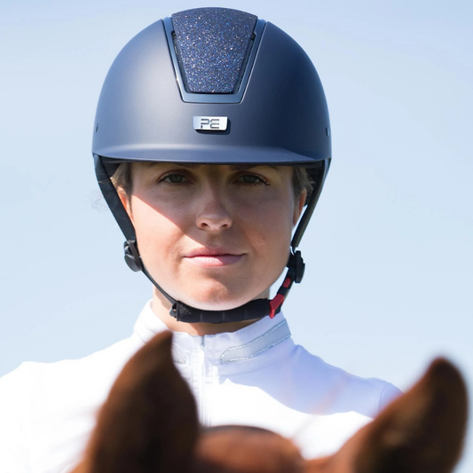 Alzarrab PE Odyssey Horse Riding Helmet worn by a female rider outdoors, featuring a navy color and stylish design.